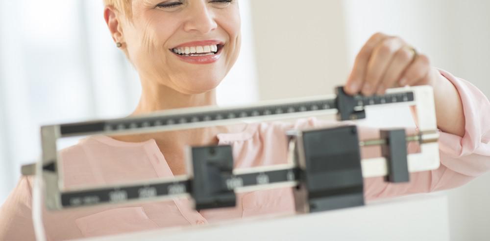 woman using a scale to weigh herself